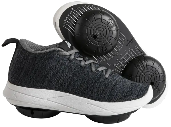 A pair of Apos® biomechanical shoes showing the calibrated pods on the underside